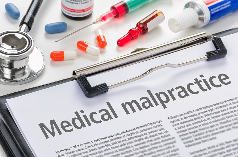 A medical malpractice law paper with some pills and needles